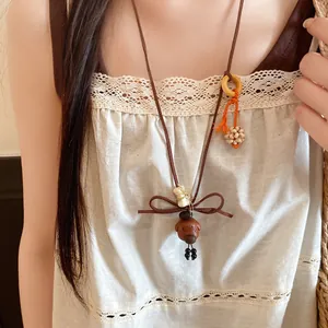 Detail of a vintage cute dog pendant necklace with wood beads worn by a model
