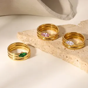 Detail von drei 18k vergoldeten Edelstahlringen mit bunten Marquise-Zirkonia Steinen.