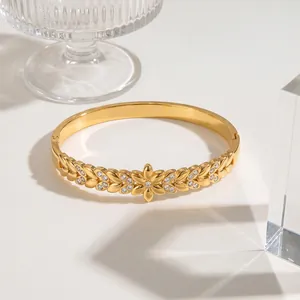 Close-up of a gold-plated stainless steel floral bangle with sparkling crystal accents