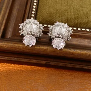 Nahaufnahme eleganter Silberohrringe mit glitzernden Zirkonia und runden Perlen.