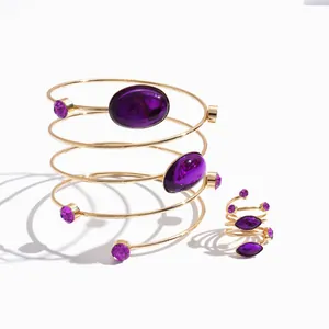 Elegantes Set aus vergoldetem Spiralarmband und Ring mit lila ovalen Acrylsteinen