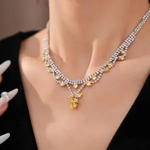 Detailansicht einer eleganten Silberkette mit gelben Zirkonia-Tropfenanhängern am Model