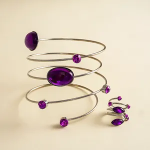 Detailansicht eines Retro-Spiralarmreifs und Ringsets mit violetten Acryl-Edelsteinen