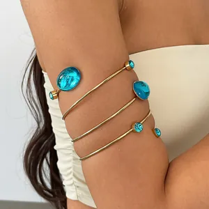 Detailansicht eines Vintage Gold-Armreifs mit türkisfarbenen Acryl-Ovalsteinen am Modell