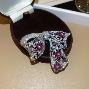 Gedetailleerde close-up van een sprankelende zirkoon bloemenstrik broche met accenten.
