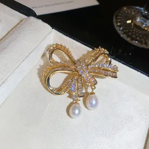 HD close-up van een luxe zirkoon strikbroche met twee elegante druppelvormige parels