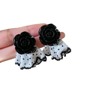 Korean style black rose stud earrings with white polka dot fabric skirt charm detail.