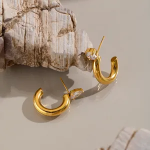 Detailansicht der 18K vergoldeten C-Ohrringe mit glänzendem Zirkonia-Schmuckstein.