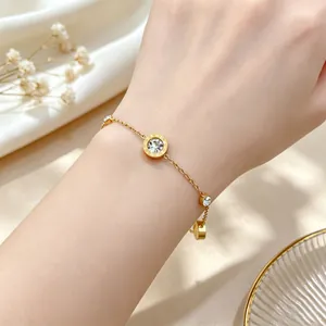 Primo piano di un bracciale in acciaio al titanio dorato con numeri romani e cristalli