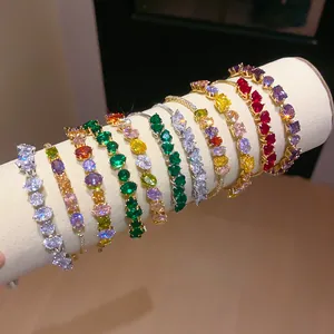 Close-up macro view of various colorful 18k gold plated zircon bracelets on white stand