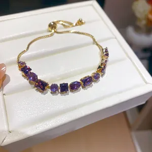 Detail view of an 18k gold plated bracelet with sparkling purple geometric zircon stones