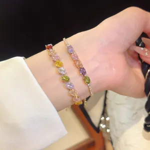 Detailed view of colorful oval cubic zirconia 18k gold plated bracelets on wrist