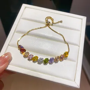 Detailed macro view of an 18k gold-plated bracelet with multi-colored zirconia stones.