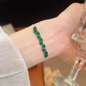 Detailed view of a sparkling heart-shaped green zircon bracelet with 18k gold plating