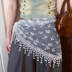 Close-up of a white floral lace mesh waist scarf accessory on a model's outfit