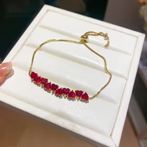 Detailed close-up of 18k gold plated bracelet with sparkling red heart-shaped stones