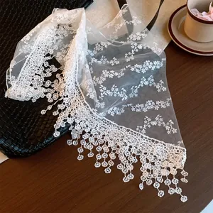 Detail view of white floral lace mesh waist scarf with elegant fringe tassels