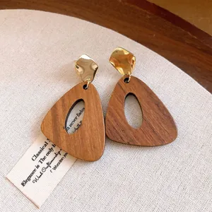 Detailed view of vintage irregular wooden earrings with gold-toned metallic geometric accents