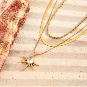 Detail van een drielaagse 18K vergulde ketting met een sprankelende sterrenhanger