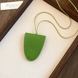 Vue détaillée du collier porte-lunettes magnétique en cuir vert texturé sur plateau