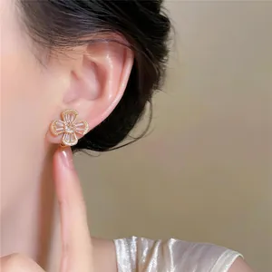 Detailed macro view of a sparkling zircon flower clip-on earring worn on an elegant ear