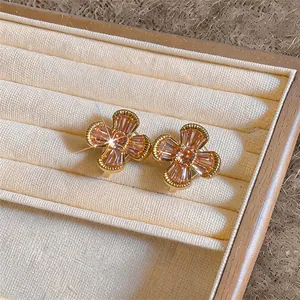 Detailed view of champagne zircon flower clip-on earrings on a velvet jewelry tray