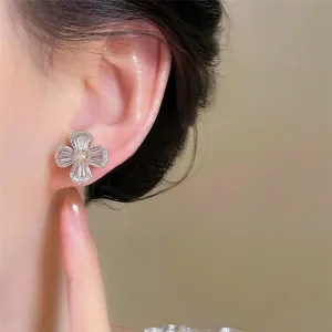 Detailed view of elegant flower-shaped clip-on earrings with sparkling zirconias on ear