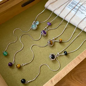 Détail de colliers pendentif hexagramme avec perles de pierre colorées sur chaîne serpent