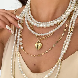 Detaillierte Nahaufnahme einer mehrlagigen Retro-Perlenkette mit goldenem Herzanhänger