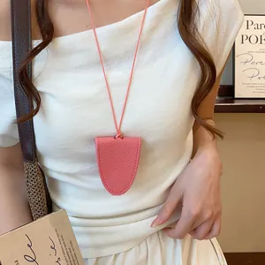 Détail d'un collier porte-lunettes magnétique en cuir rose porté par un mannequin