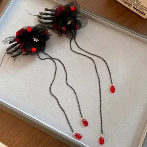 Pince à cheveux fleur noire gothique avec mains de squelette et longs glands rouges