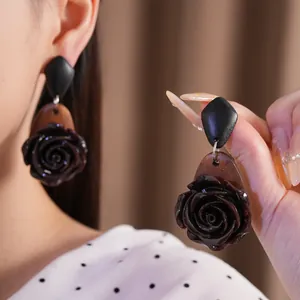 Detailaufnahme der dunkelbraunen Rosen-Ohrringe aus Harz und Holz im Vintage-Stil.