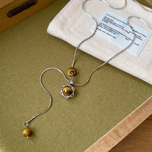 Gros plan détaillé d'un collier pendentif hexagramme avec des perles en œil de tigre