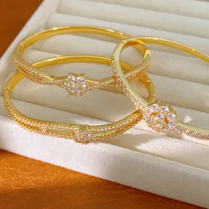Detailansicht vergoldeter 18K Blumenarmreifen mit CZ-Steinen in einer Box