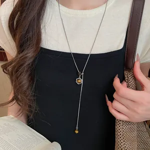 Vue détaillée d'un collier pendentif hexagramme oeil de tigre minimaliste sur un mannequin