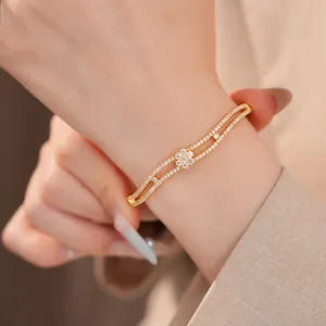 Detailaufnahme eines 18K vergoldeten Armbands mit funkelndem Zirkonia-Blumendesign