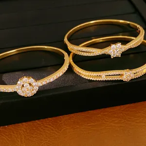 Detailansicht von 18 Karat vergoldeten Armreifen mit funkelnden Zirkonia-Blumendesigns