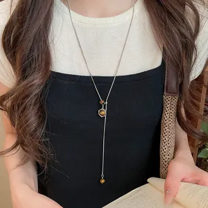 Vue détaillée d'un long collier minimaliste avec un pendentif hexagramme en œil de tigre