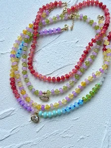 Detailed view of colorful dopamine-style glass beaded necklaces with sparkling gold pendants