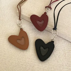 Vue détaillée de trois pendentifs en cuir en forme de cœur avec lanières de cou