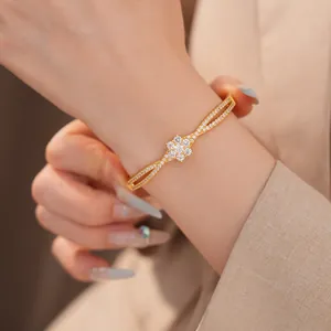 Elegantes Armband mit 18 Karat Vergoldung und Zirkonia-Blume, am Handgelenk getragen.