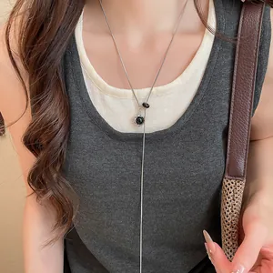 Gros plan d'un collier minimaliste en forme d'étoile hexagonale porté par un mannequin