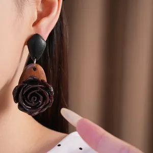 Nahaufnahme von eleganten Holz- und Harz-Ohrringen im Vintage-Stil mit Rosenmotiv