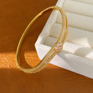 Detailansicht eines 18K vergoldeten Zirkonia-Armreifs mit eleganter Blumenschnalle