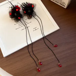 Mollette per capelli a mano di scheletro gotico con nappe e perline rosse.