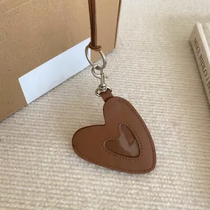 Gros plan détaillé d'un pendentif en forme de cœur en cuir marron avec fenêtre photo