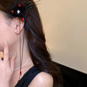 Dettaglio di un fermaglio per capelli floreale stile dark con teschio e nappe rosse