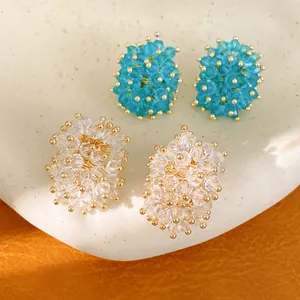 Close-up of handmade glass cluster stud earrings featuring gold beads and premium silver pins