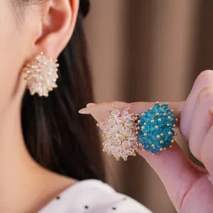Close-up detail of clustered glass bead stud earrings in blue and clear colors