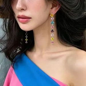 Professional detail view of long drop earrings with colorful geometric zircon stones